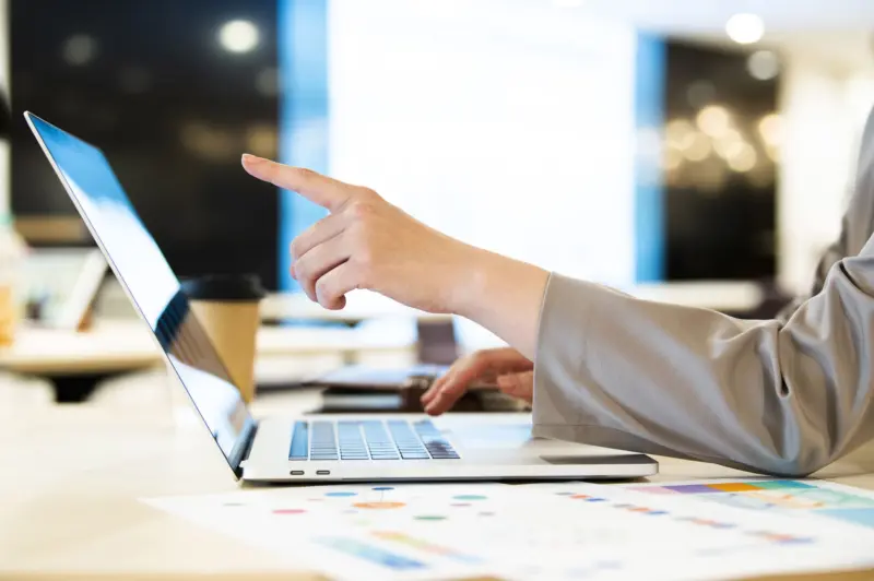 パソコンの画面に指を指す人